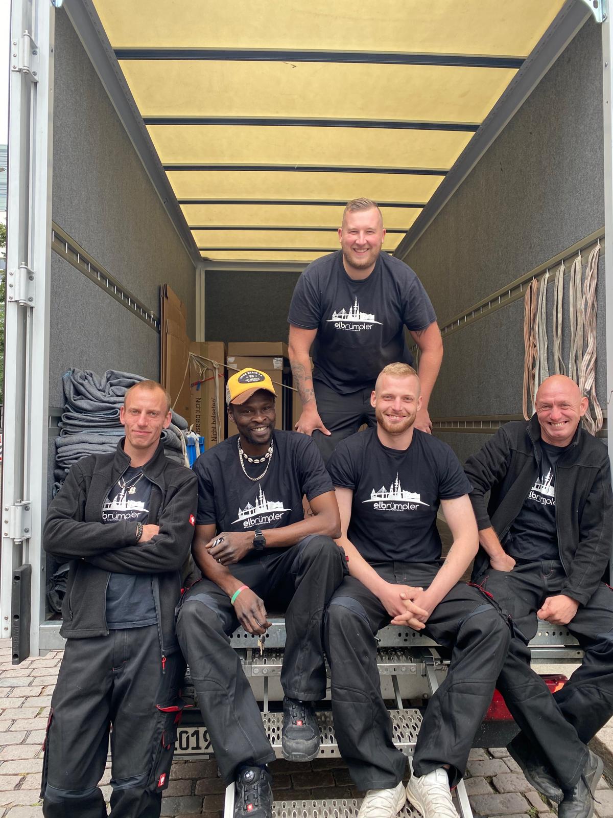 Das Team von Hamburger Umzüge vor dem roten Umzugswagen
